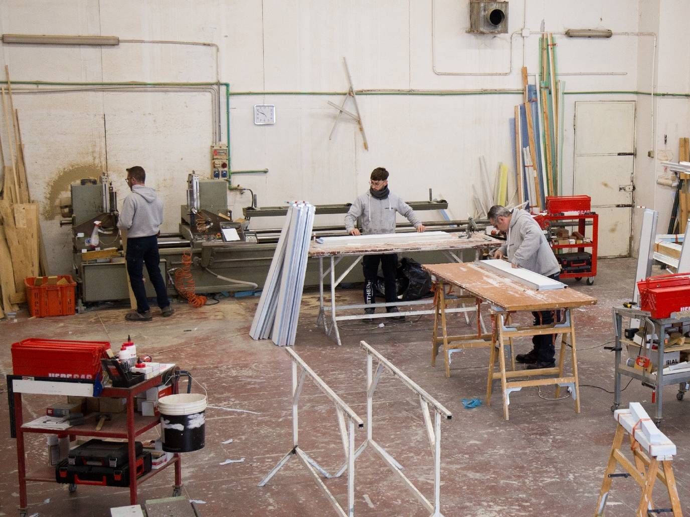 Un gruppo di uomini sta lavorando in una falegnameria