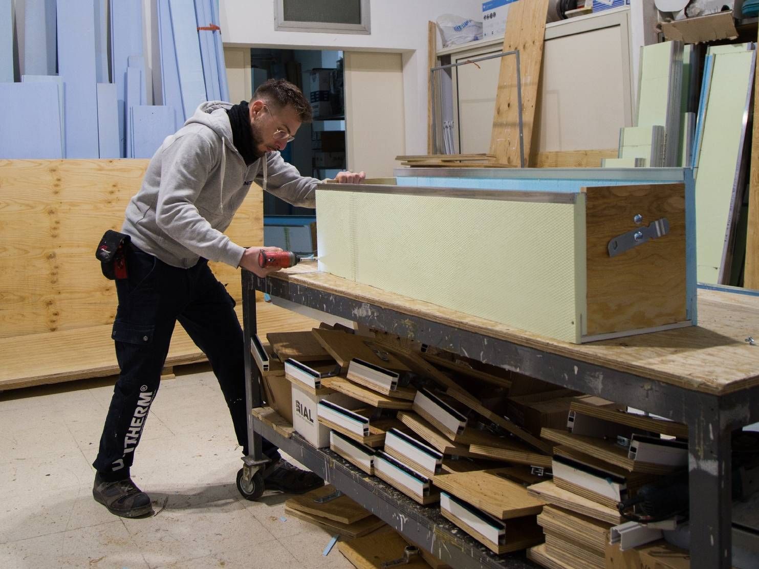 Un uomo sta lavorando su un pezzo di legno in un'officina.
