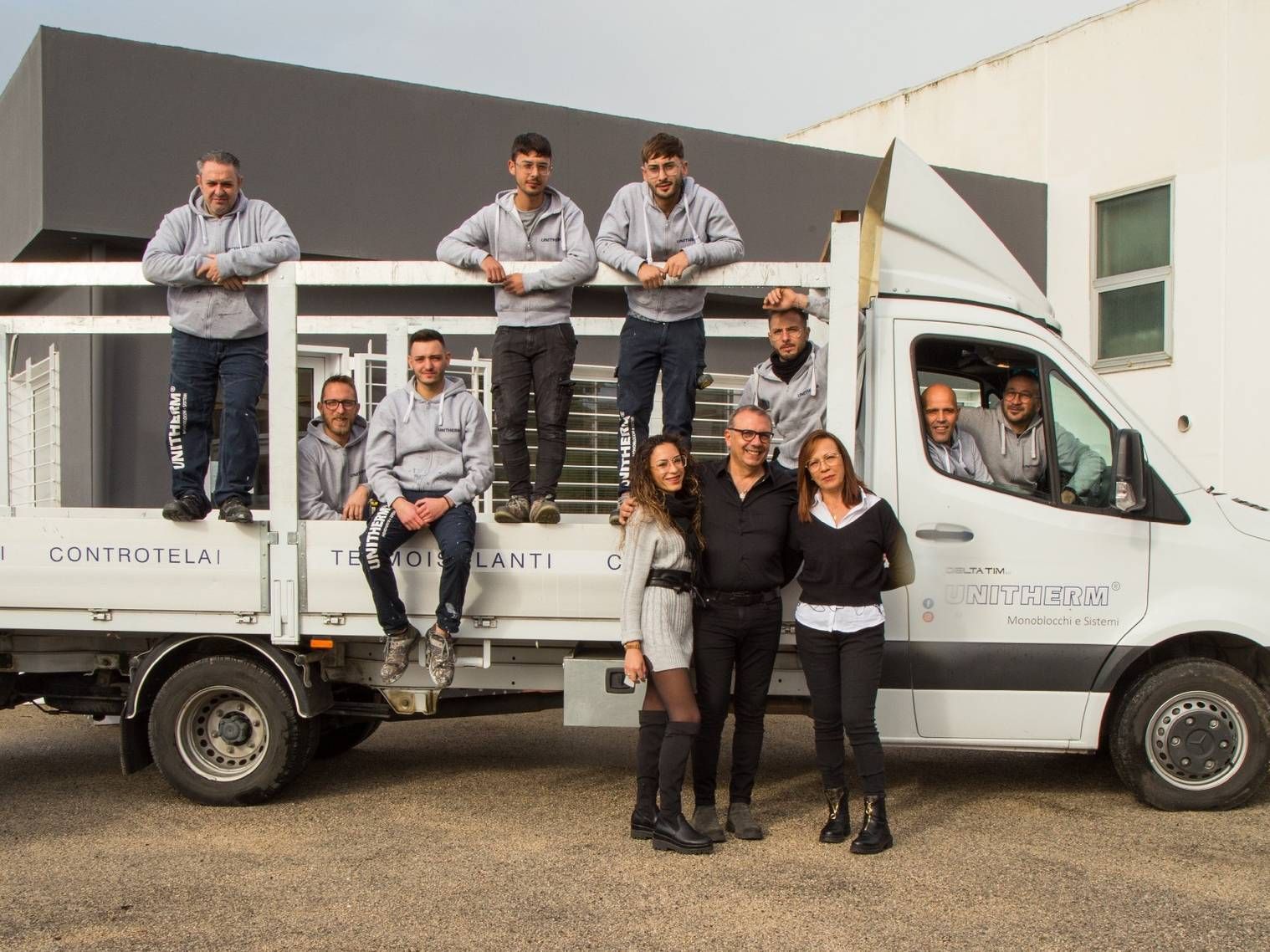 Un gruppo di persone posa per una foto davanti a un camion.