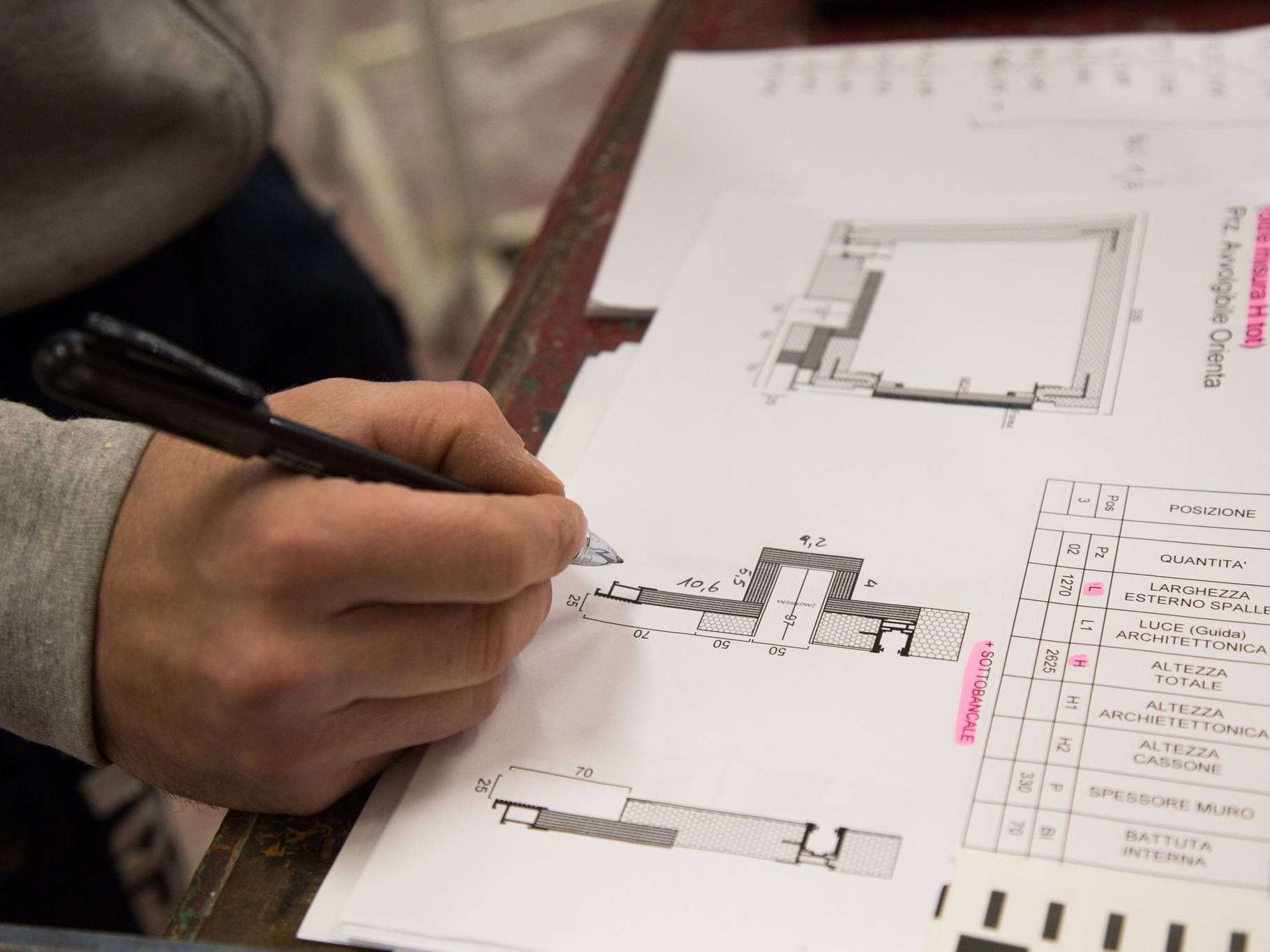 Una persona sta scrivendo su un pezzo di carta con una penna.