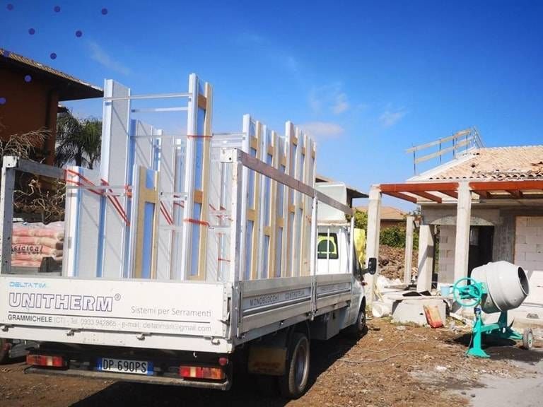 Un camion bianco è parcheggiato davanti a una casa in costruzione.