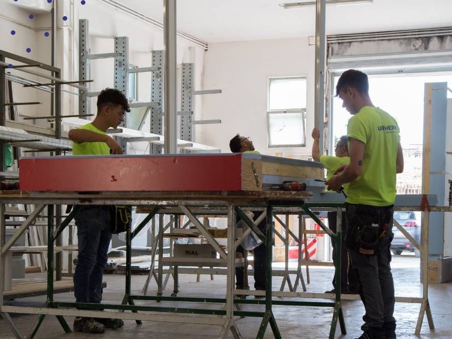 Un gruppo di uomini sta lavorando su un pezzo di legno in una fabbrica.