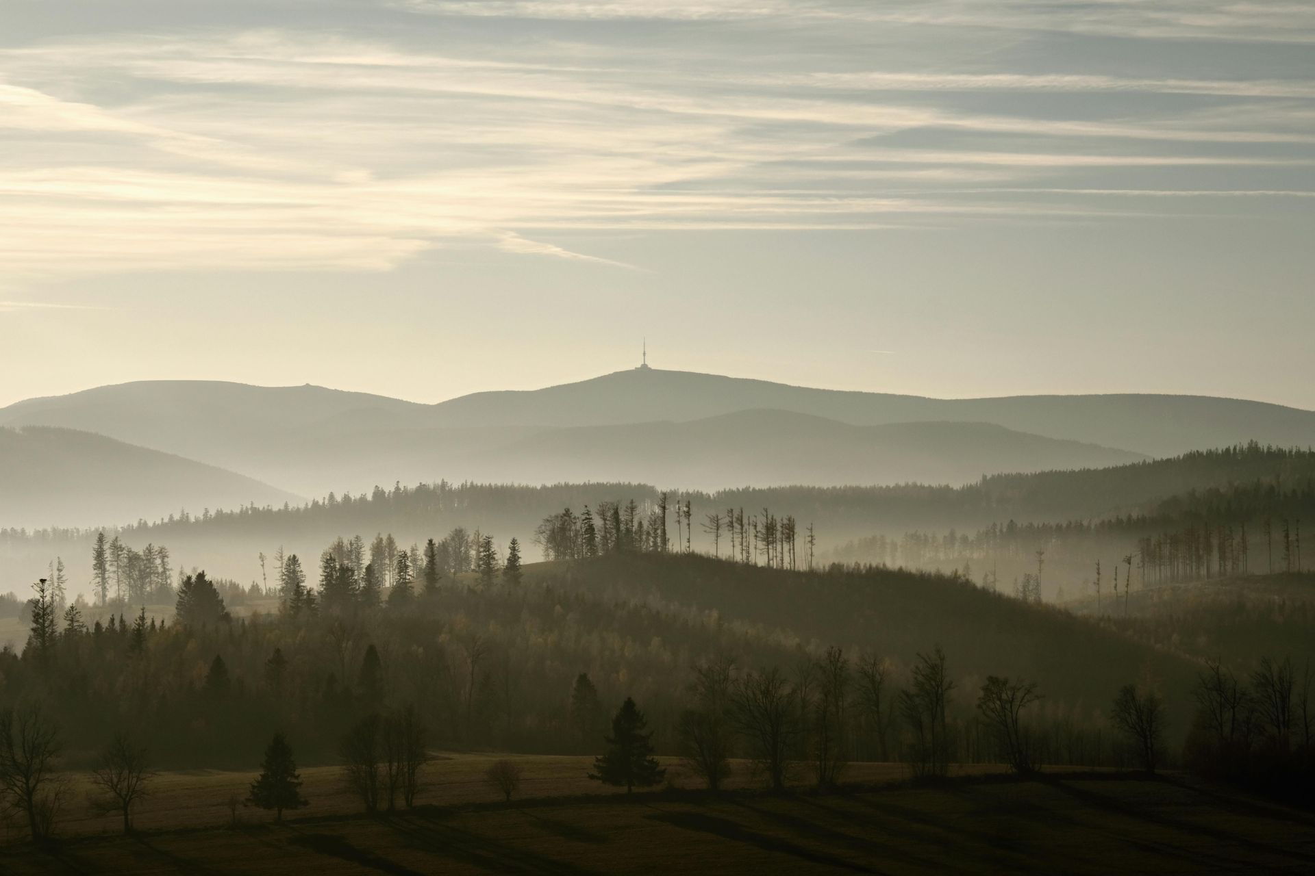 A man in a blue shirt and tie is using a laptop computer.