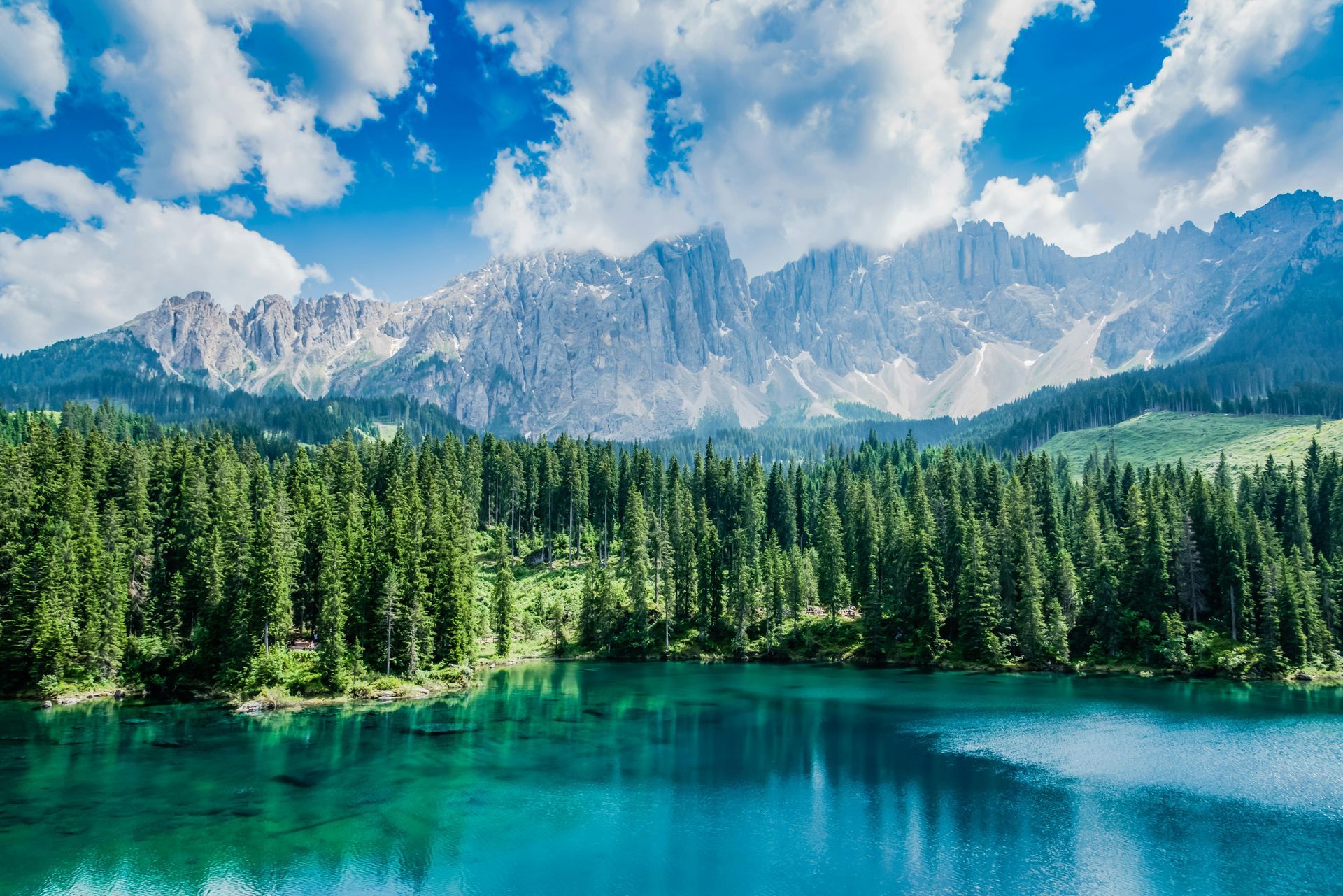A man in a blue shirt and tie is using a laptop computer.