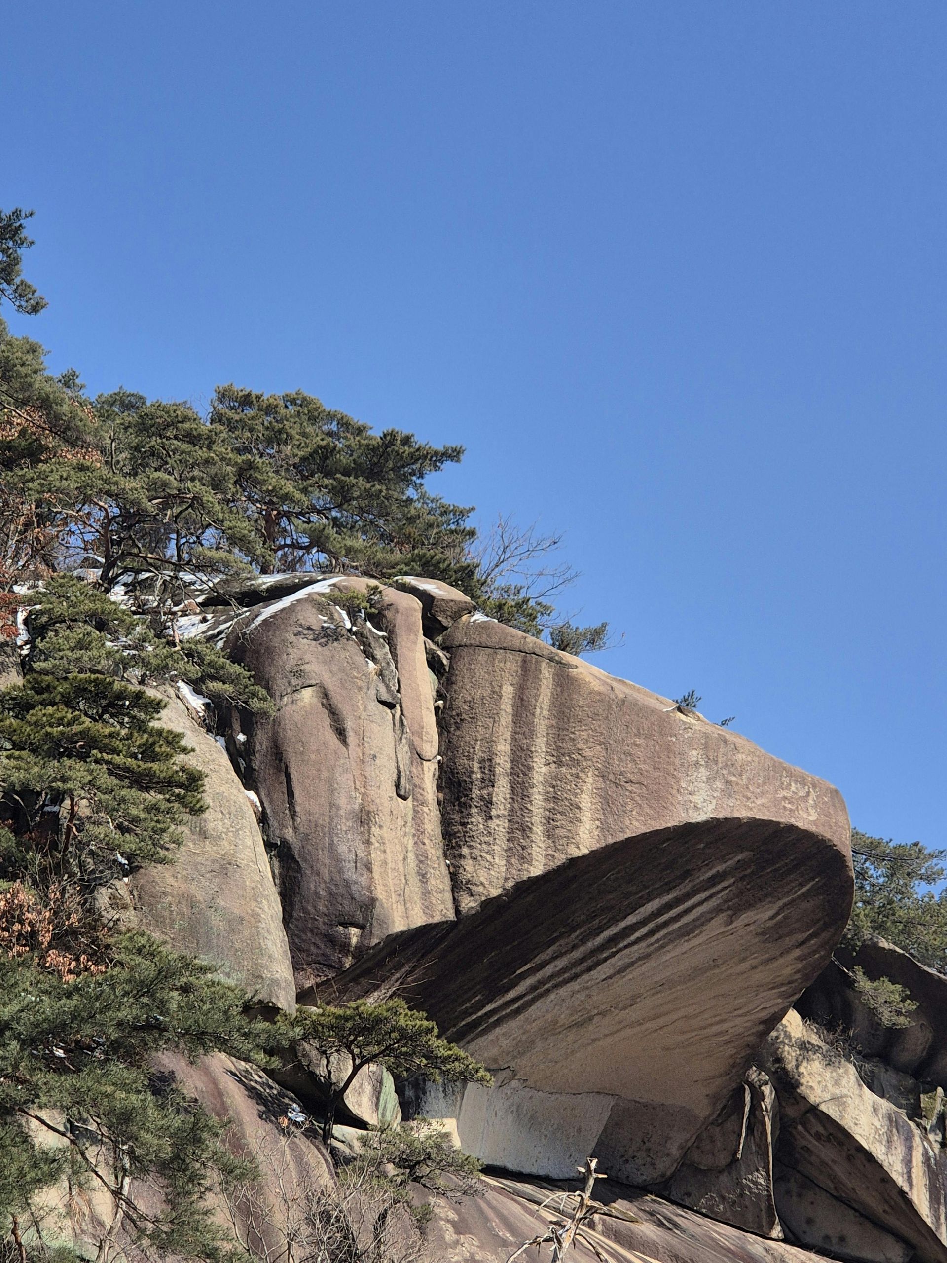 A man in a blue shirt and tie is using a laptop computer.