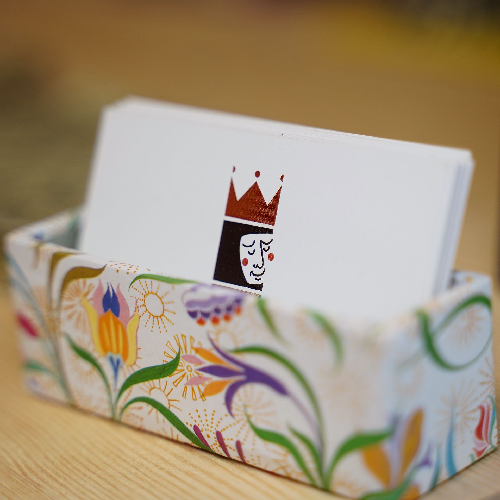 Le carte raffiguranti una regina sono inserite in un contenitore con motivo floreale.