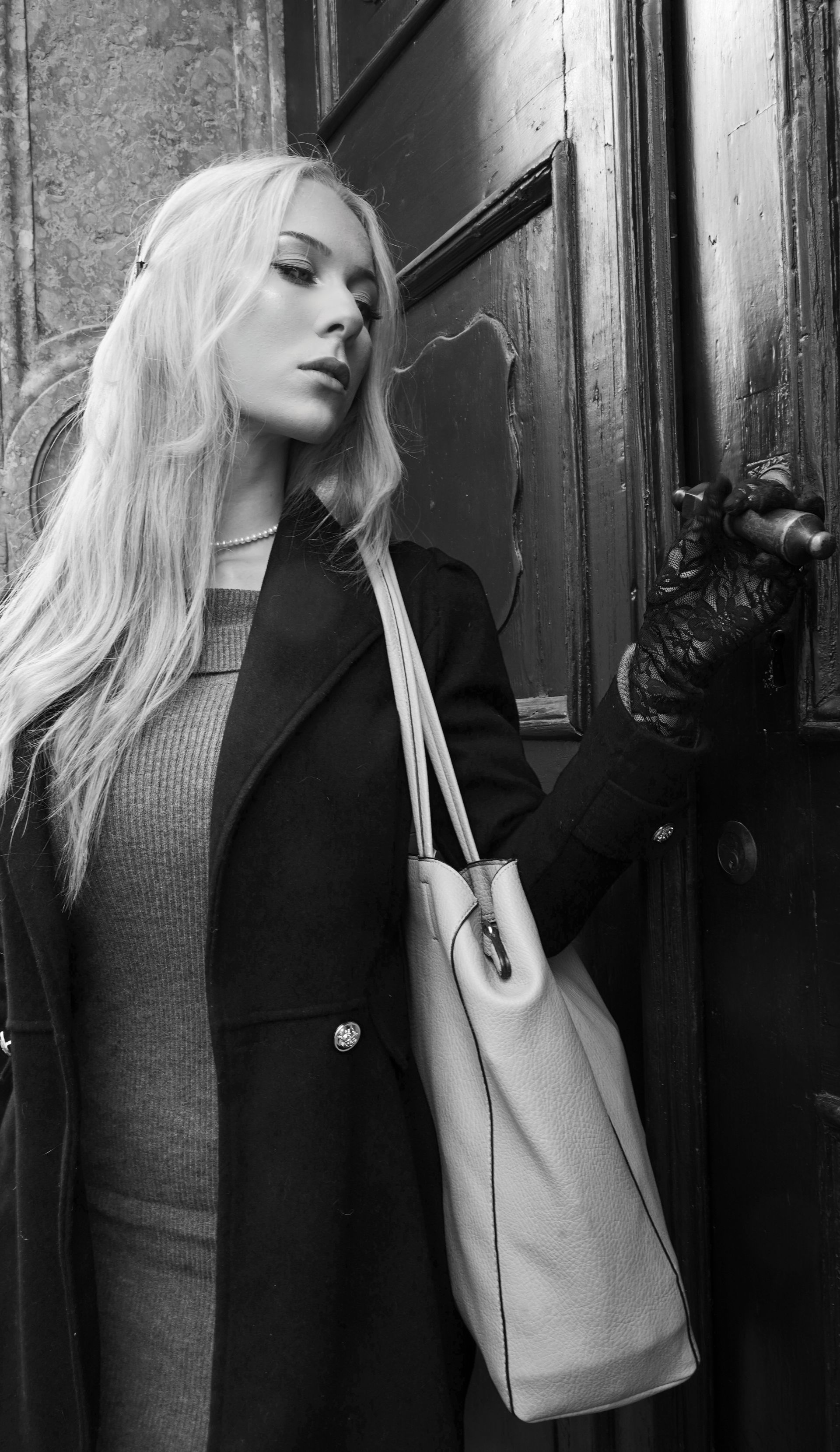 Una foto in bianco e nero di una donna con i capelli lunghi che guarda la macchina fotografica.