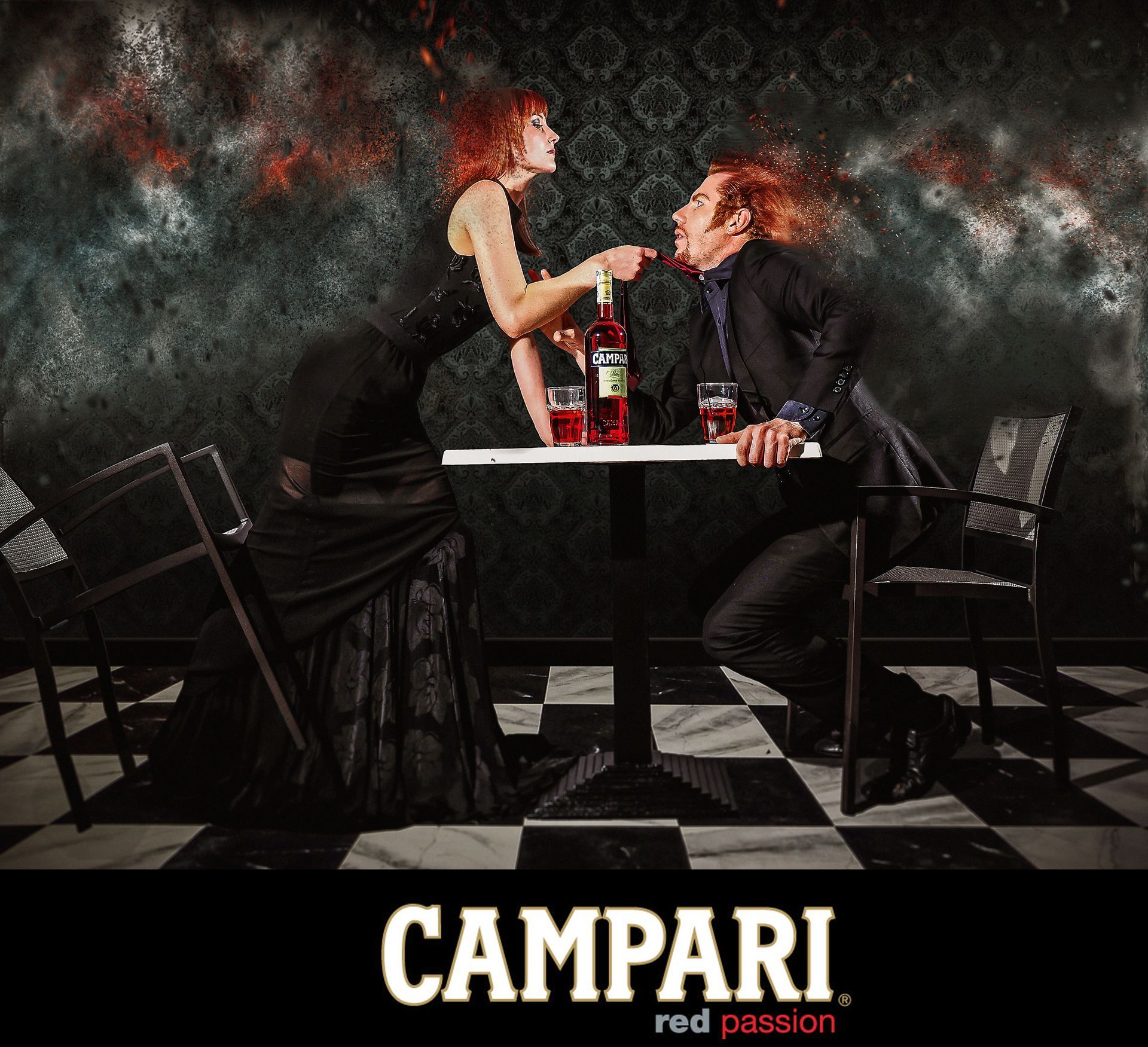Donna in abito nero che indica la bottiglia all'uomo. Sfondo rosso e pavimento a scacchi. Logo Campari in basso.
