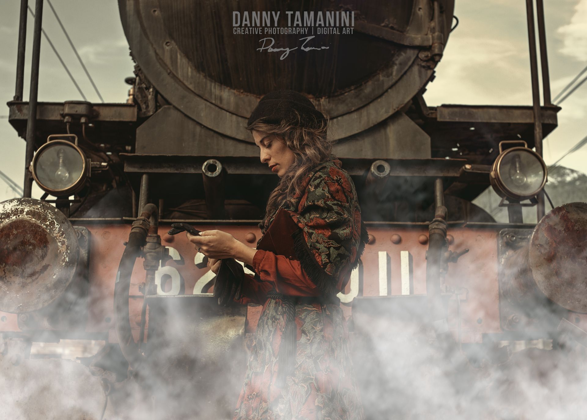 Una donna con il velo è in piedi davanti a un treno d'epoca e guarda un telefono in mezzo al vapore.