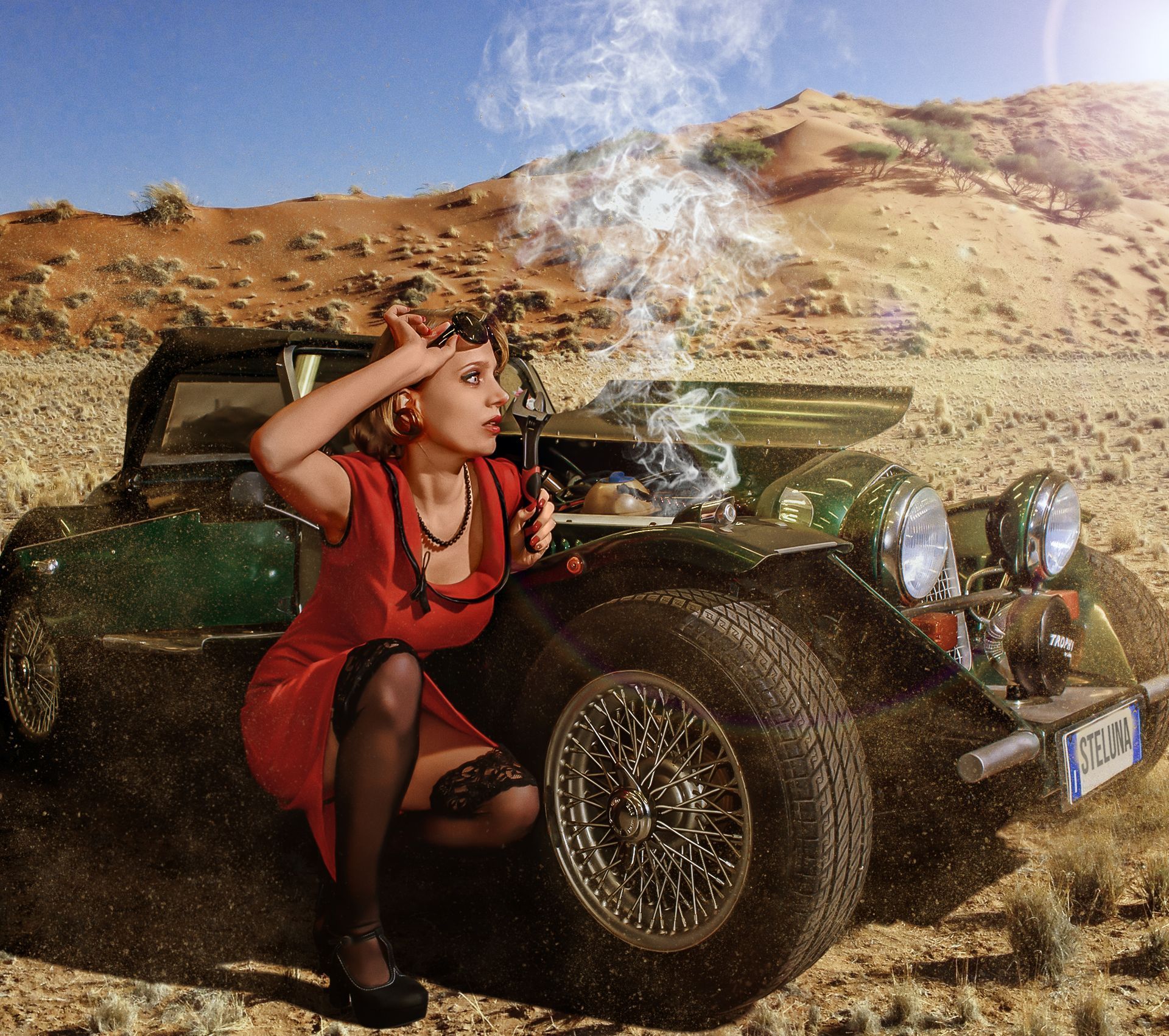 Una donna con un abito rosso e calze si inginocchia accanto a un'auto d'epoca surriscaldata nel deserto.