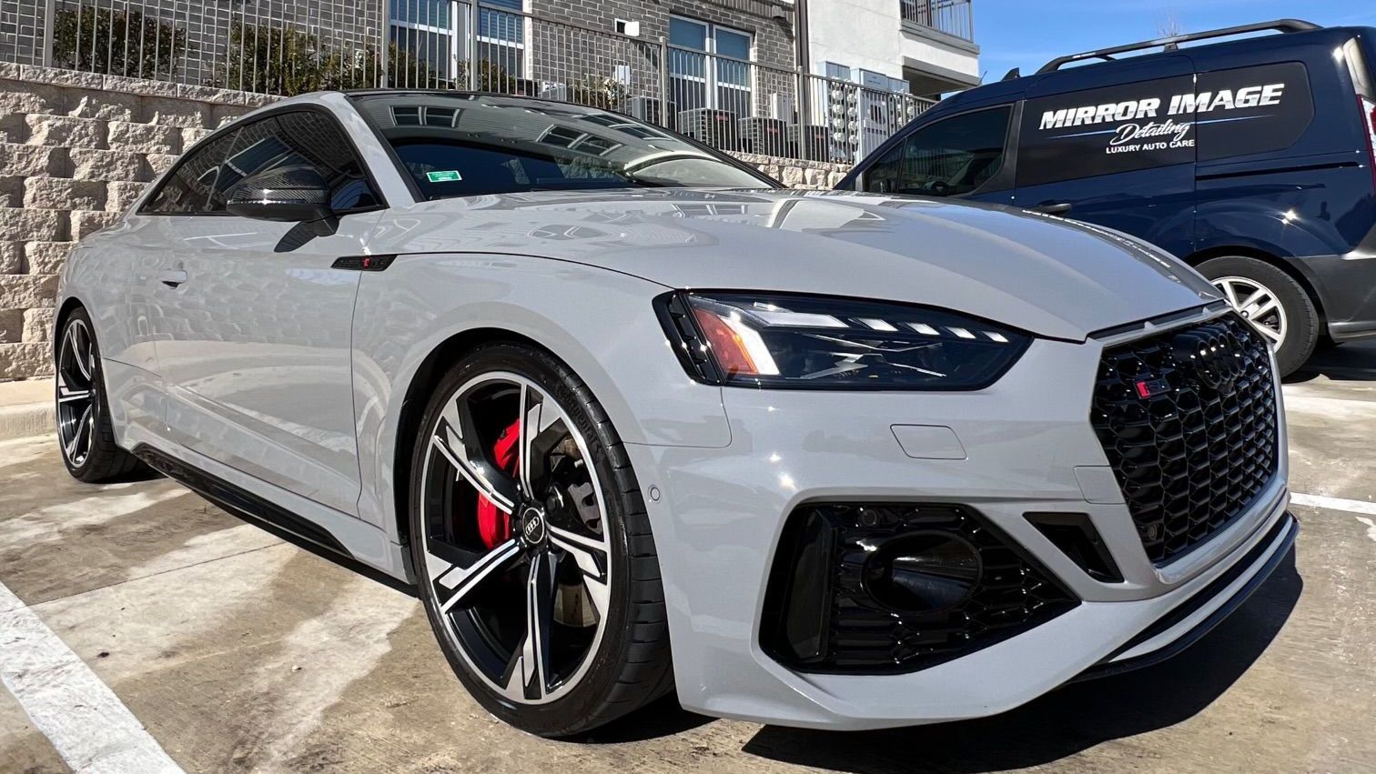 A gray audi rs 5 coupe is parked in a parking lot.