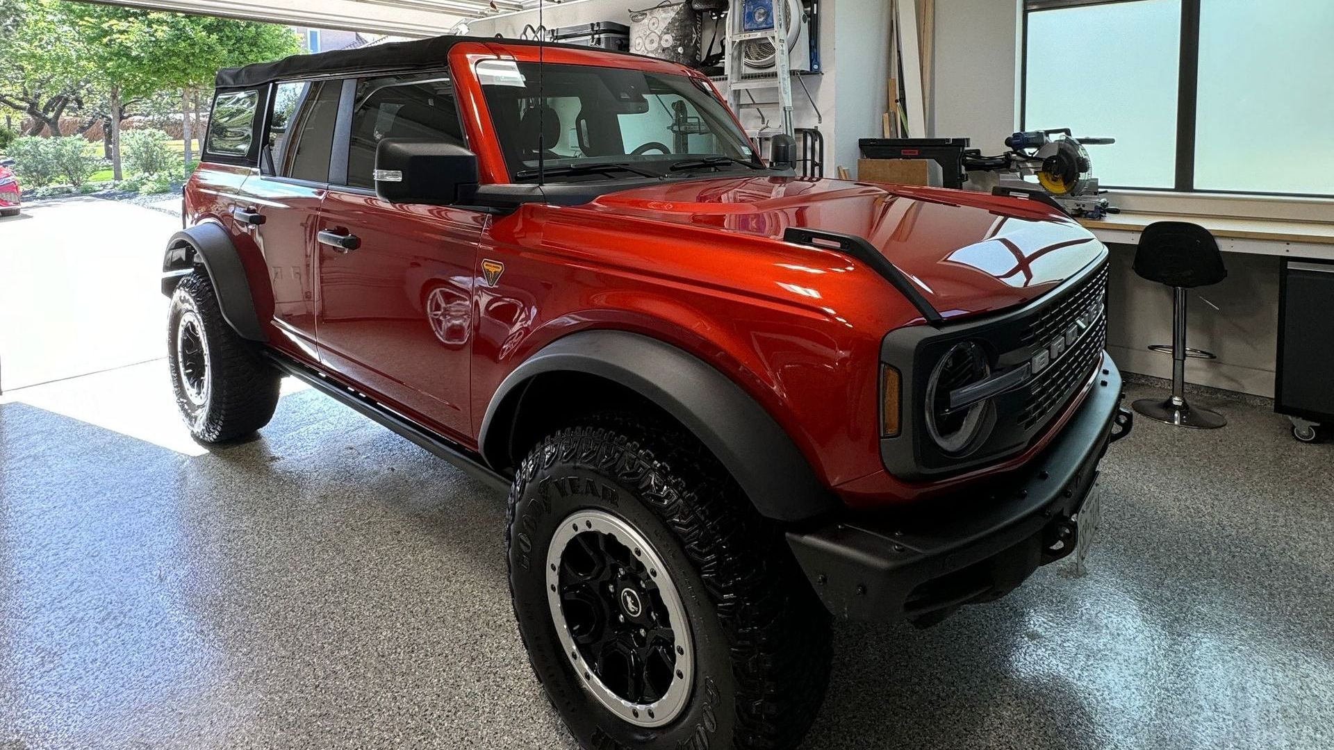 A red ford bronco is parked in a garage.