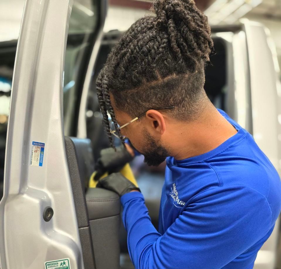 A man in a blue shirt is working on a car