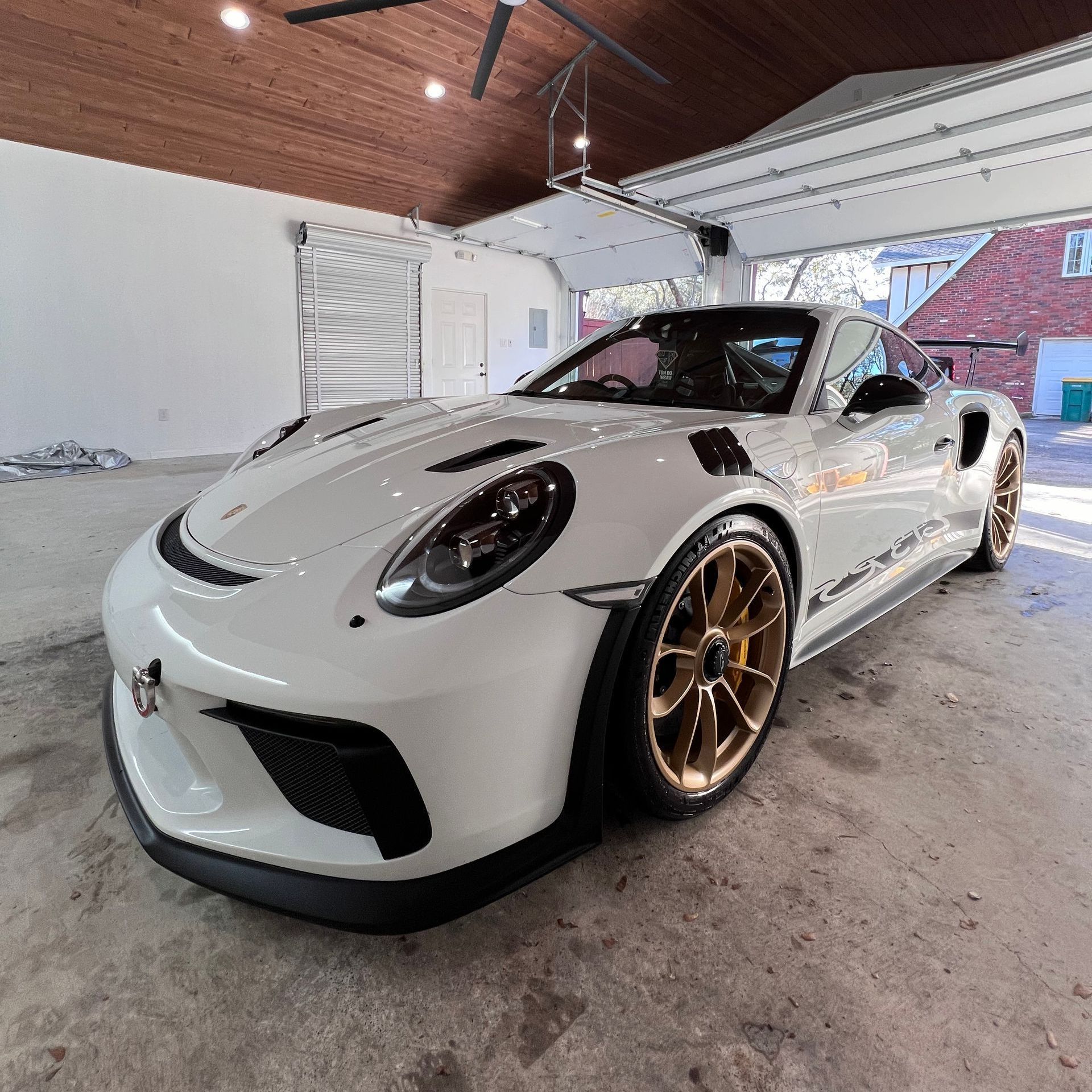A white porsche 911 gt3 rs is parked in a garage.