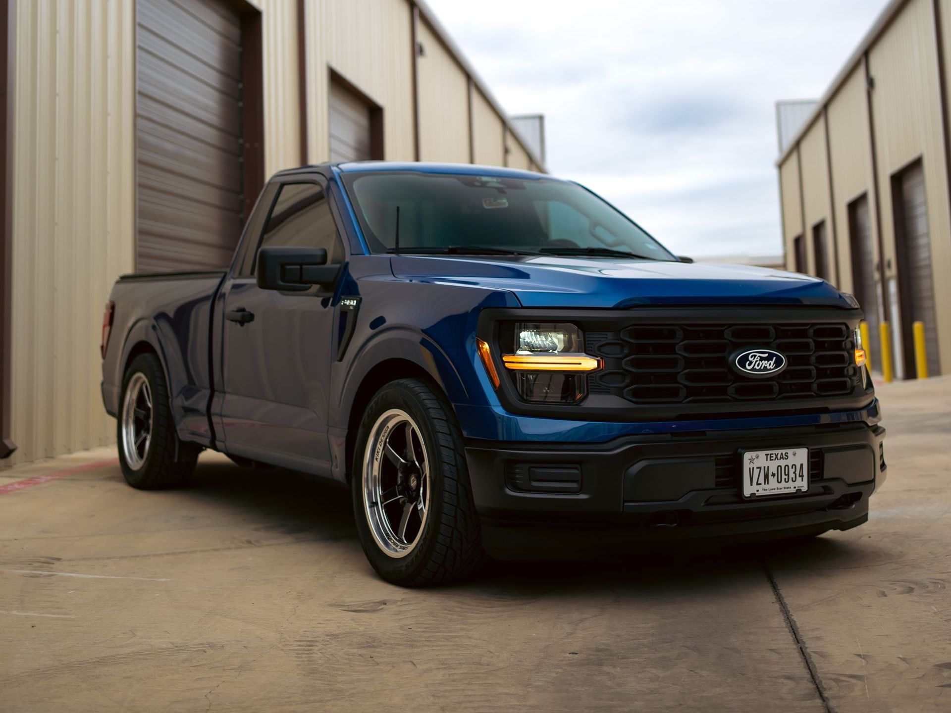 A row of cars are parked in front of a building.