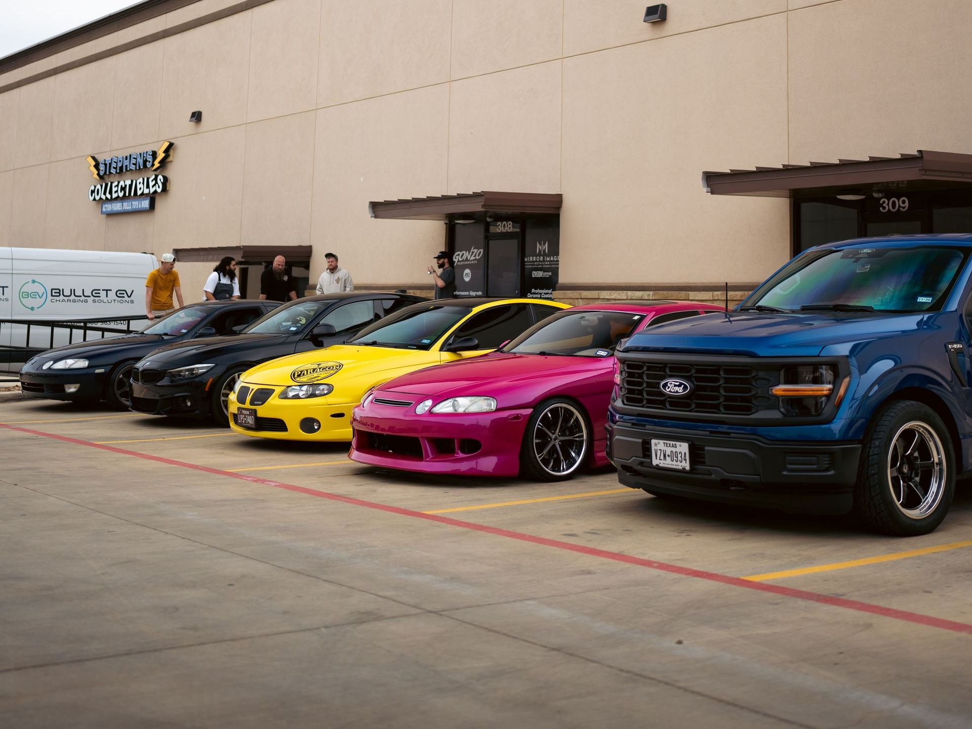 A row of cars are parked in front of a building.