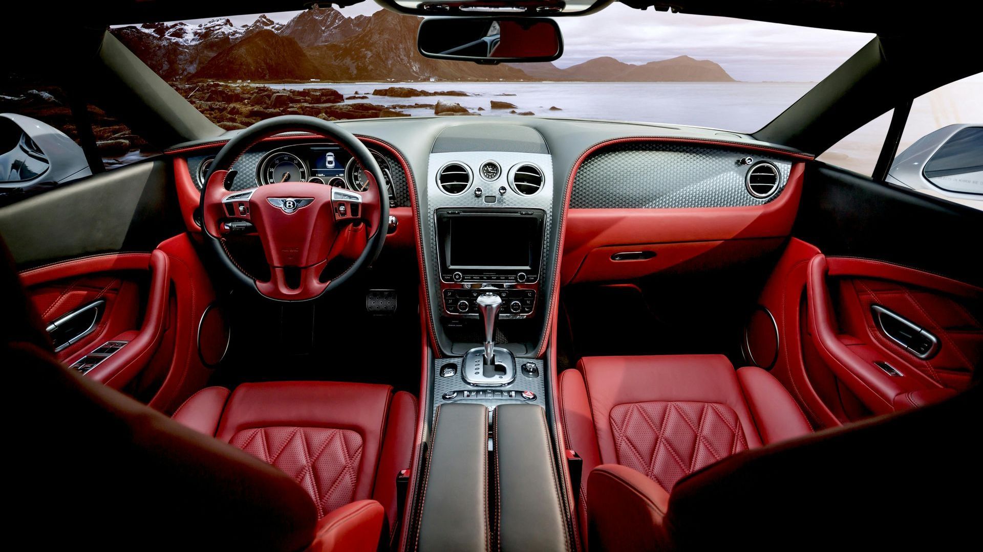 The interior of a car with red seats and a steering wheel