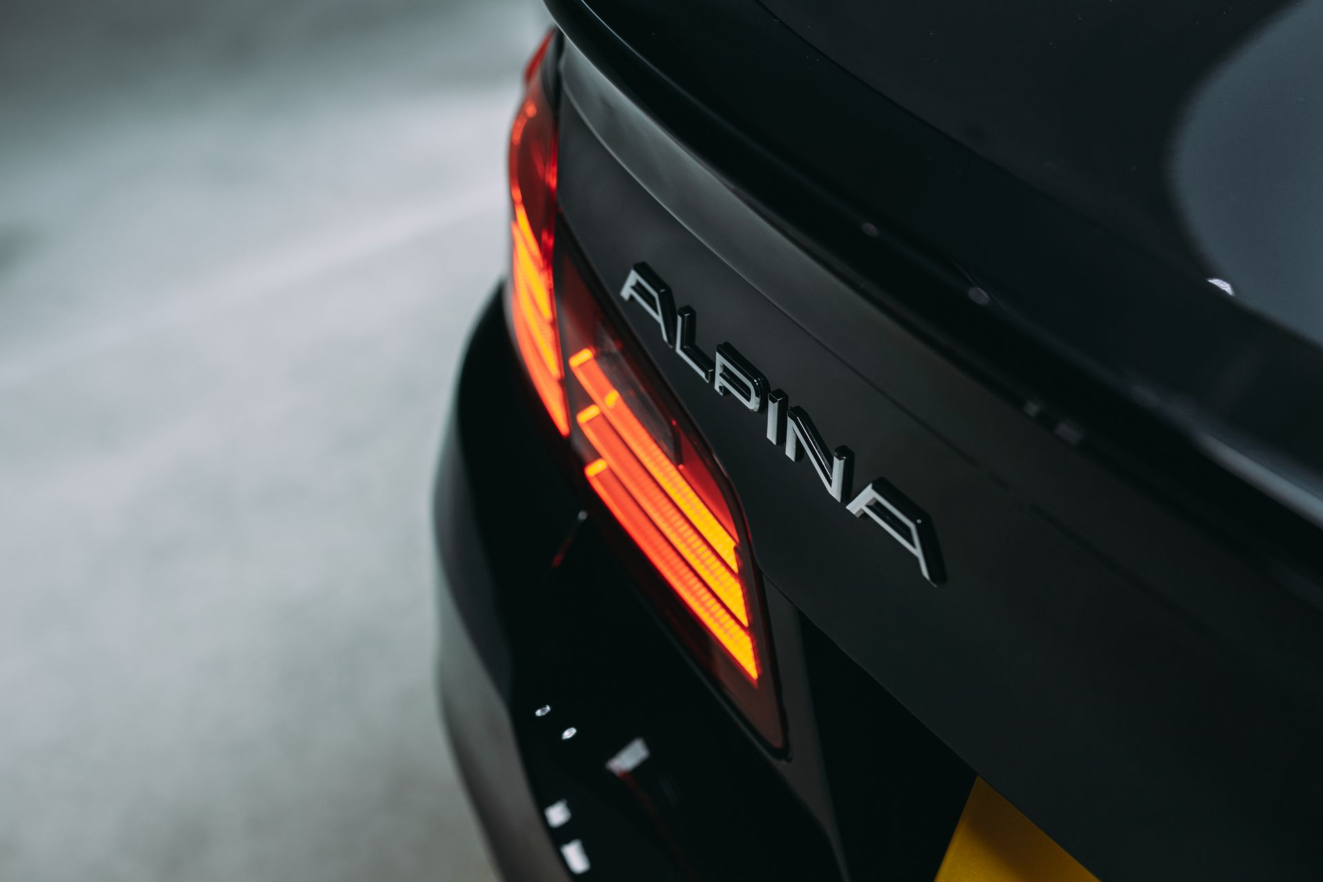A car is sitting under a heat lamp in a garage.
