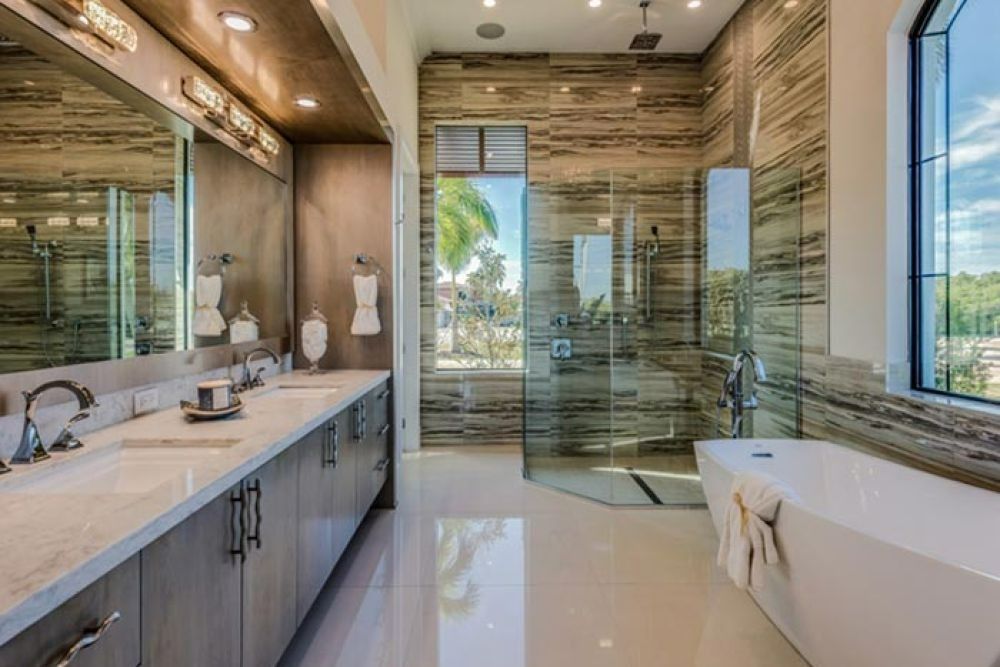 Spacious luxury bathroom with a marble vanity, glass shower, and freestanding tub.