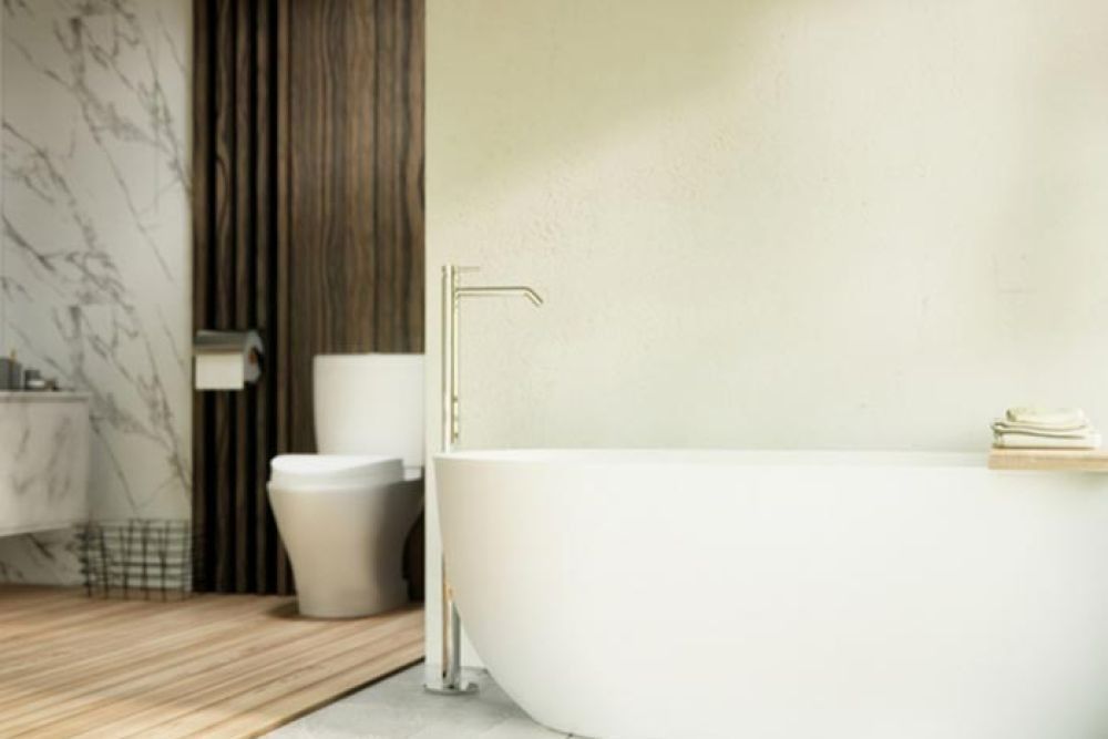 Modern bathroom with white bathtub, toilet, marble and wood panel walls, and wooden floor.