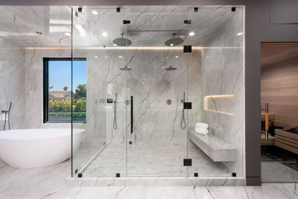 Luxurious bathroom with marble walls, glass shower, and freestanding tub.