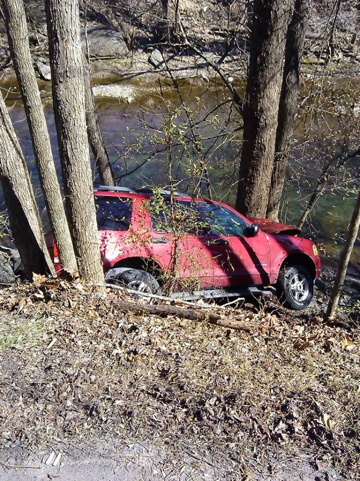 Red car stuck on trees — Pigeon Forge, TN — Carr's Auto Service