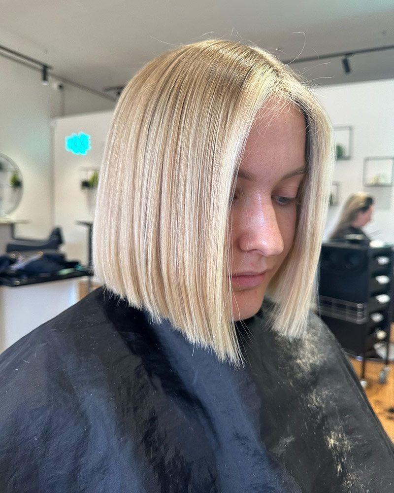 A Woman With Blonde Hair is Getting Her Hair Cut in a Salon — Hairenvy in Ettalong Beach, NSW