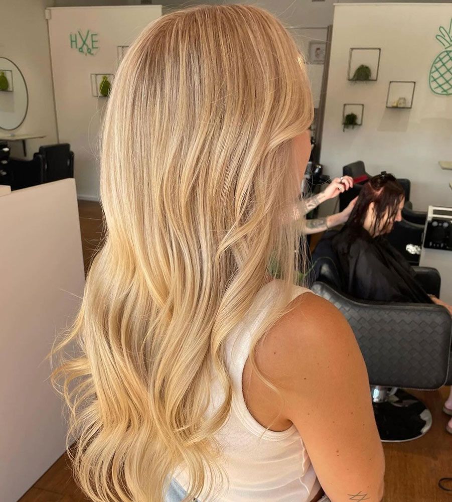 A Woman With Long Blonde Hair is Getting Her Hair Done in a Salon — Hairenvy in Ettalong Beach, NSW