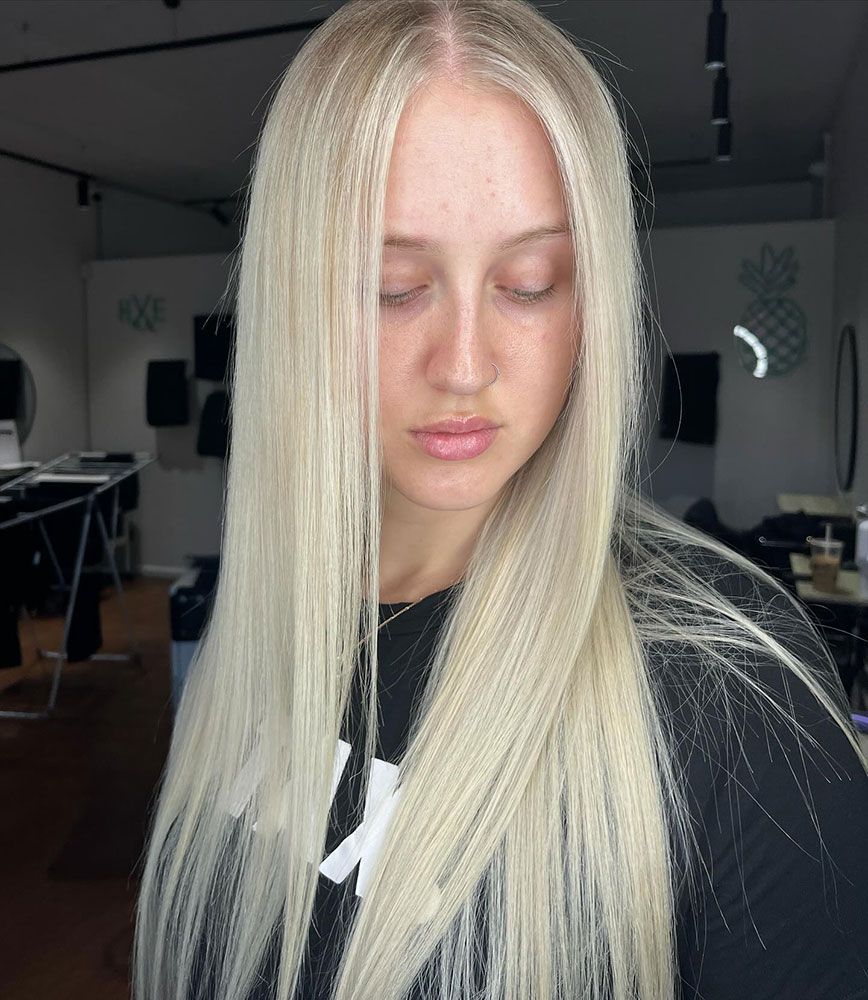 A Woman With Long Blonde Hair is Wearing a Black Shirt — Hairenvy in Ettalong Beach, NSW