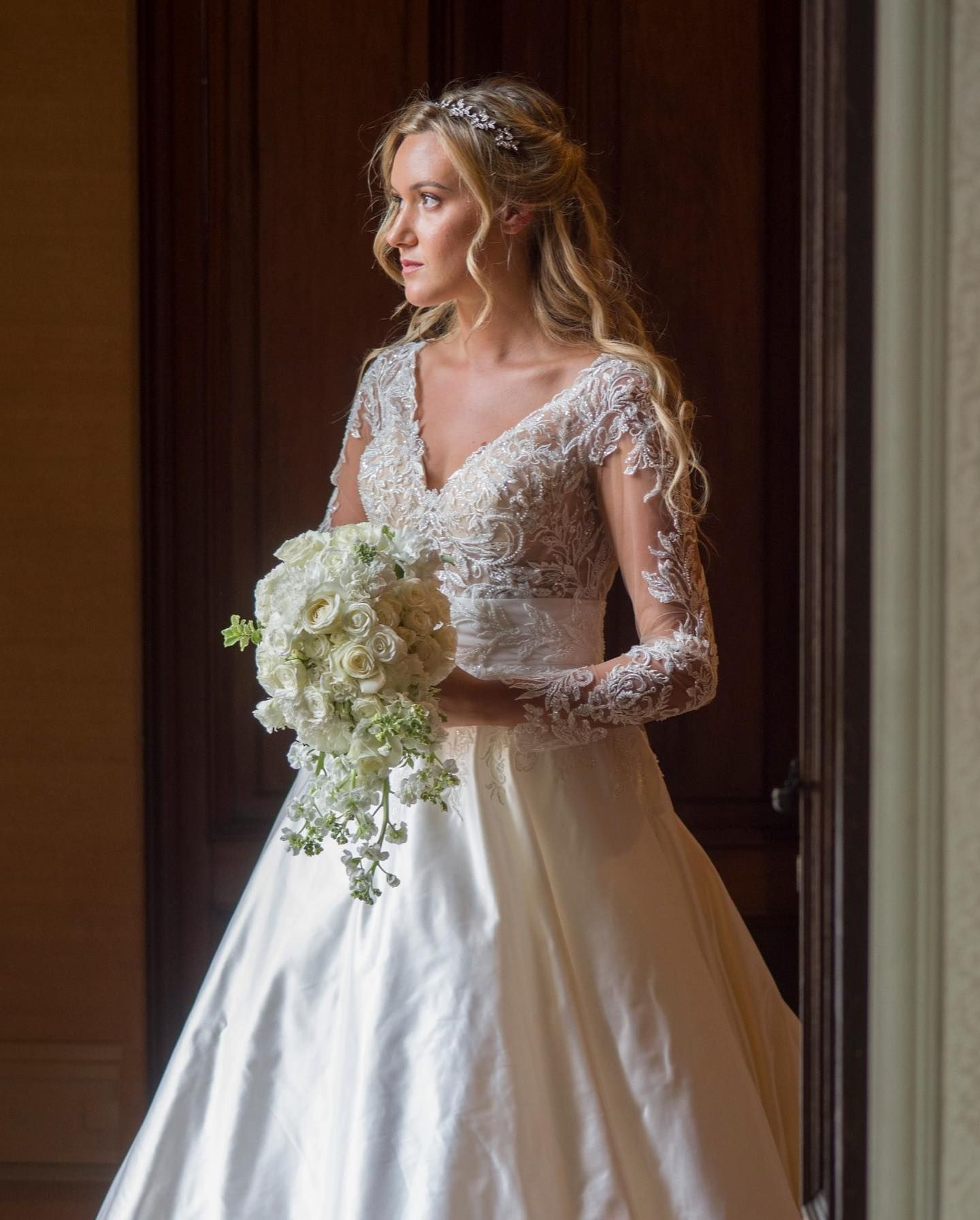 La sposa indossa un abito da sposa e tiene in mano un mazzo di fiori.