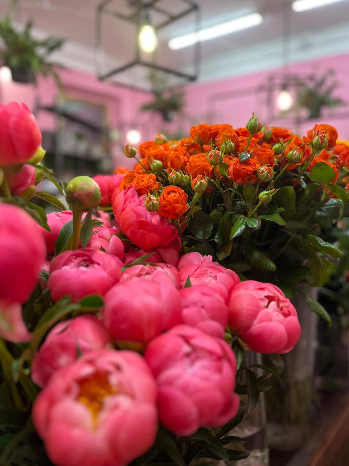 Un mazzo di fiori rosa e arancioni è seduto su un tavolo.