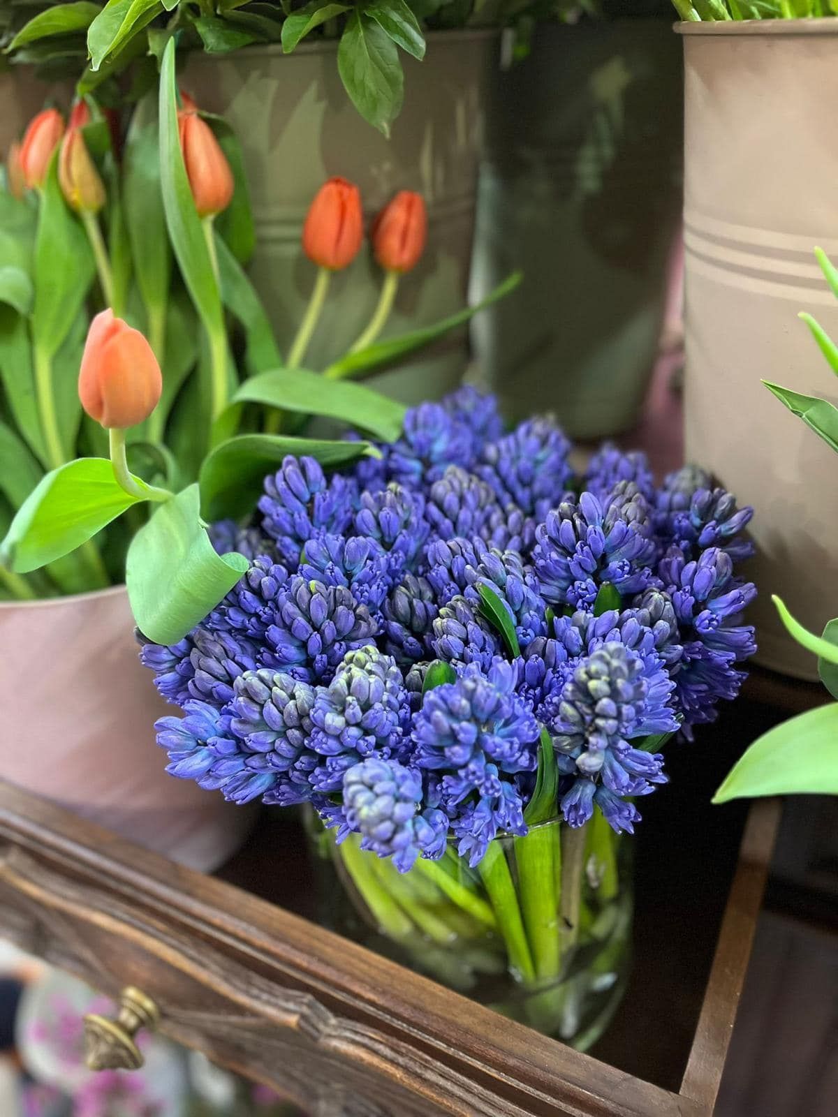 Un mazzo di fiori viola è in un vaso su un tavolo.