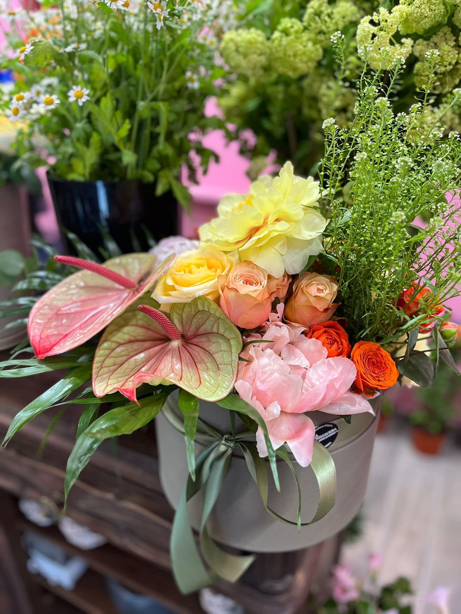 Sopra un tavolo di legno è posata una scatola piena di fiori.