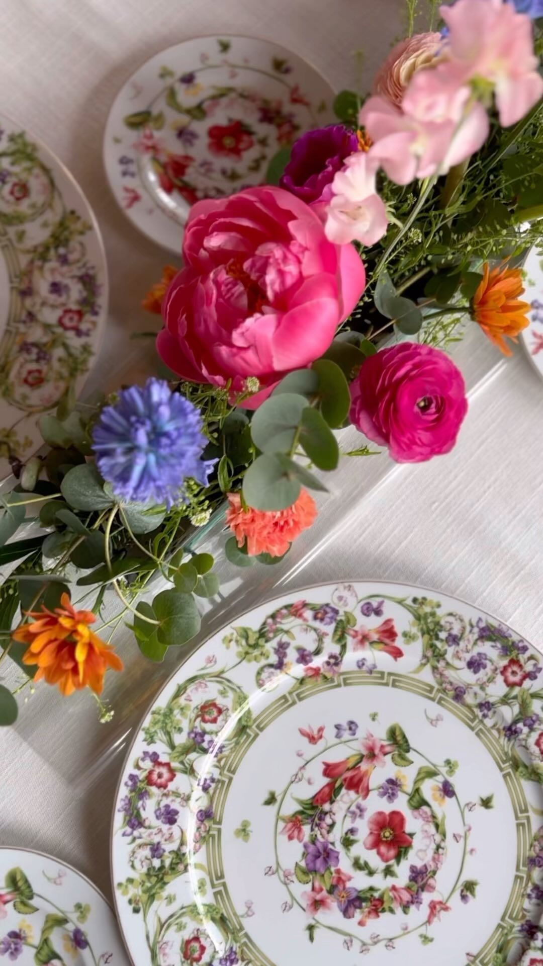 Un tavolo sormontato da piatti e un vaso di fiori.