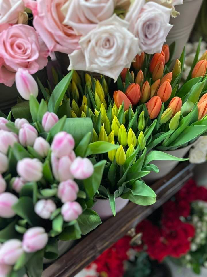 Su uno scaffale è seduto un mazzo di diversi tipi di fiori.