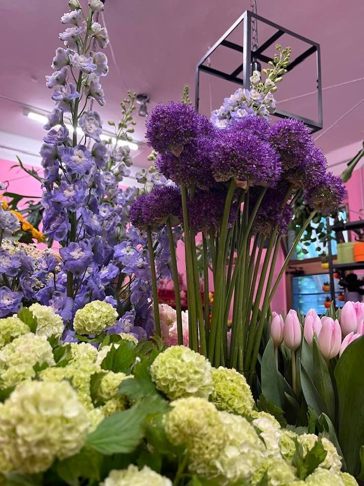 Un mazzo di fiori viola e verdi cresce in un negozio di fiori.