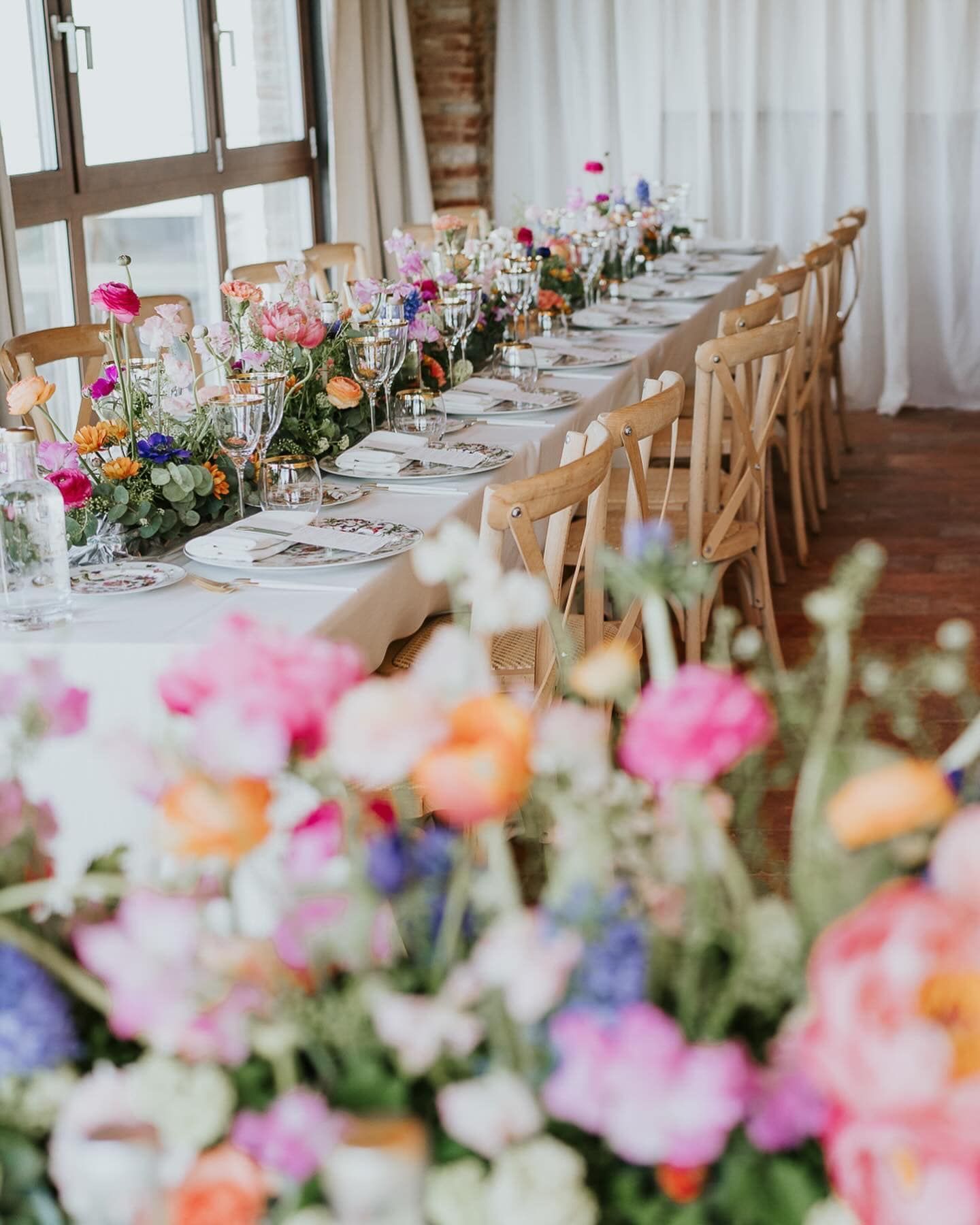 Un lungo tavolo con sopra un mazzo di fiori