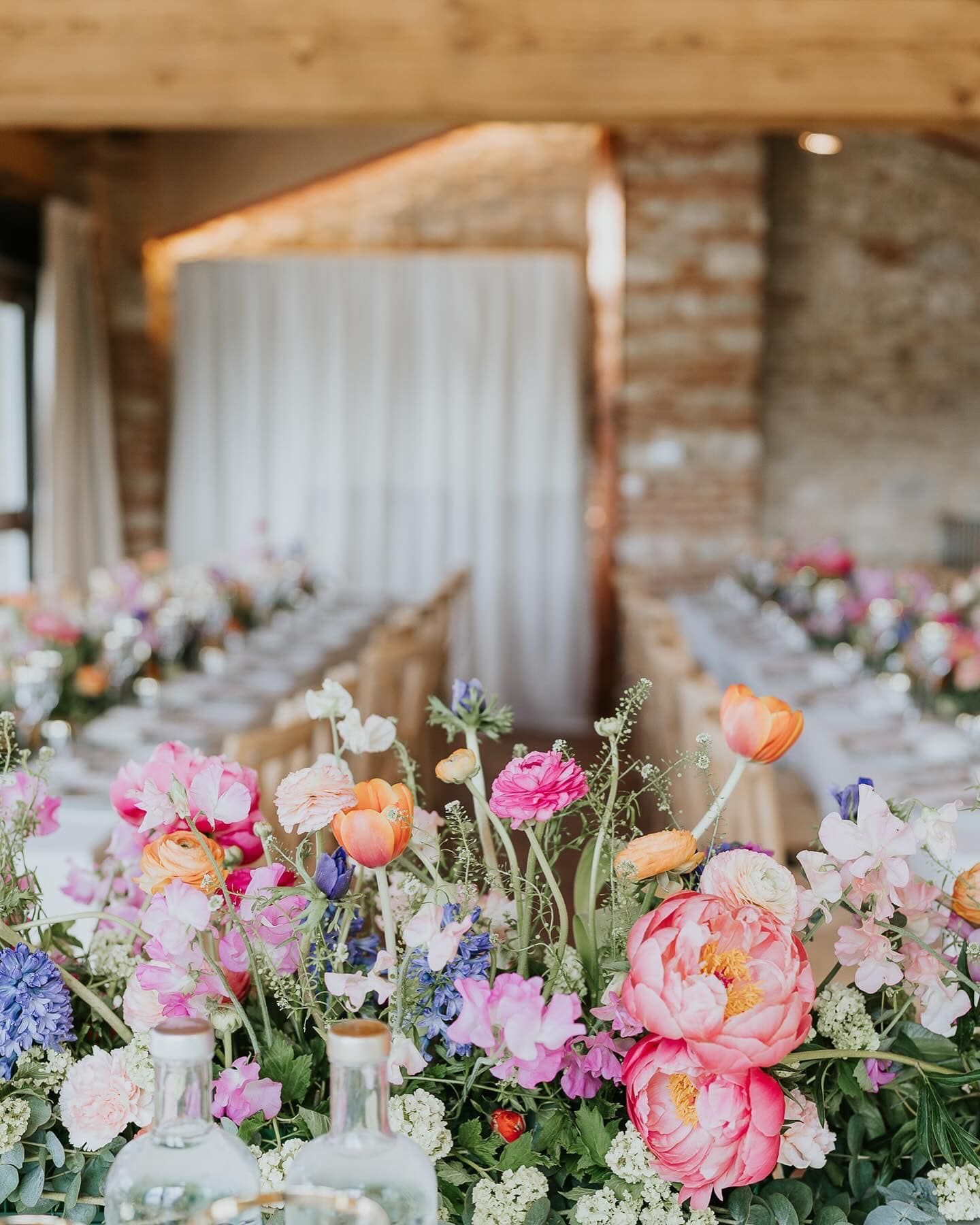 Un lungo tavolo con sopra un mazzo di fiori.