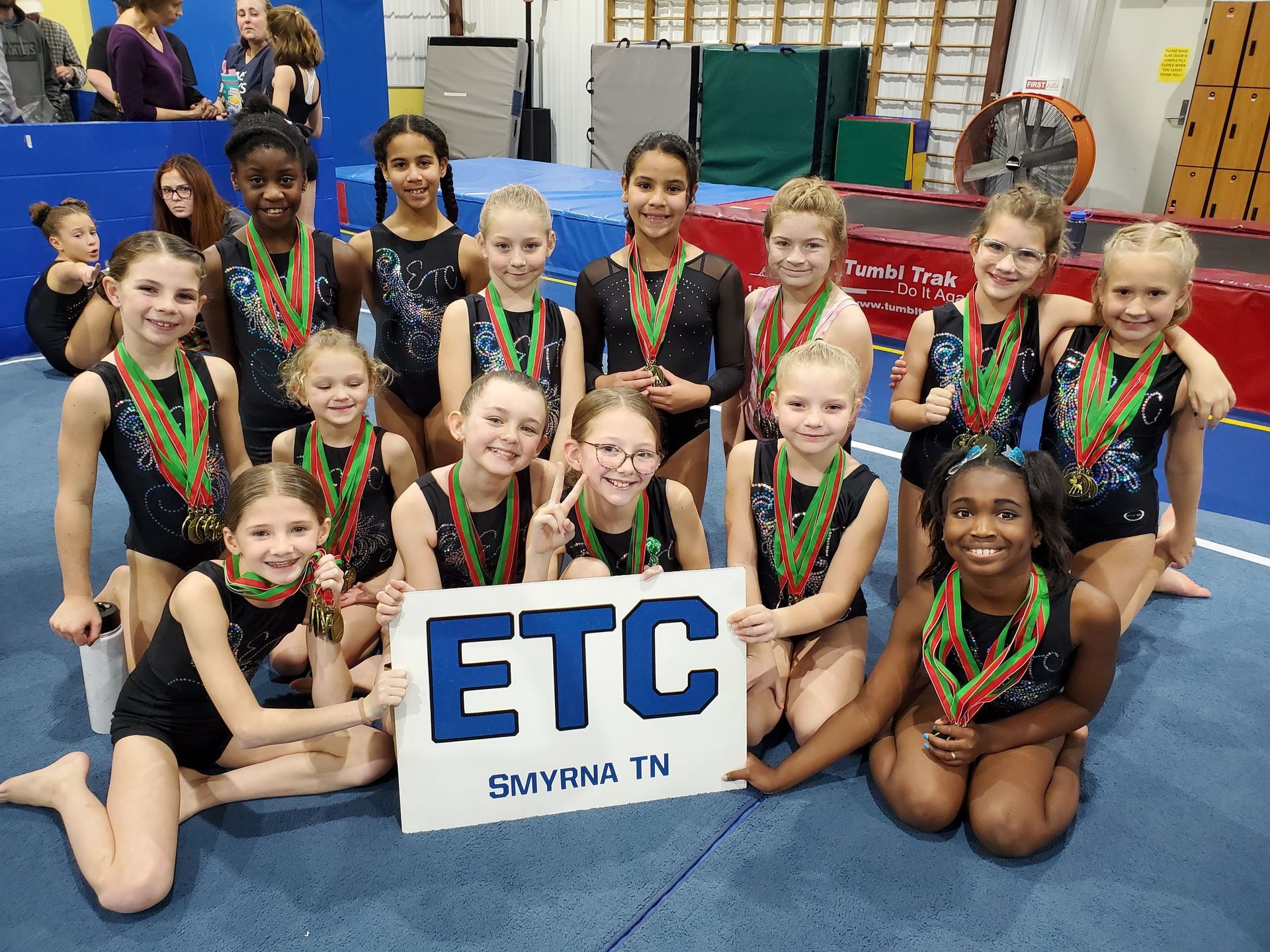 A group of young girls holding a sign that says etc