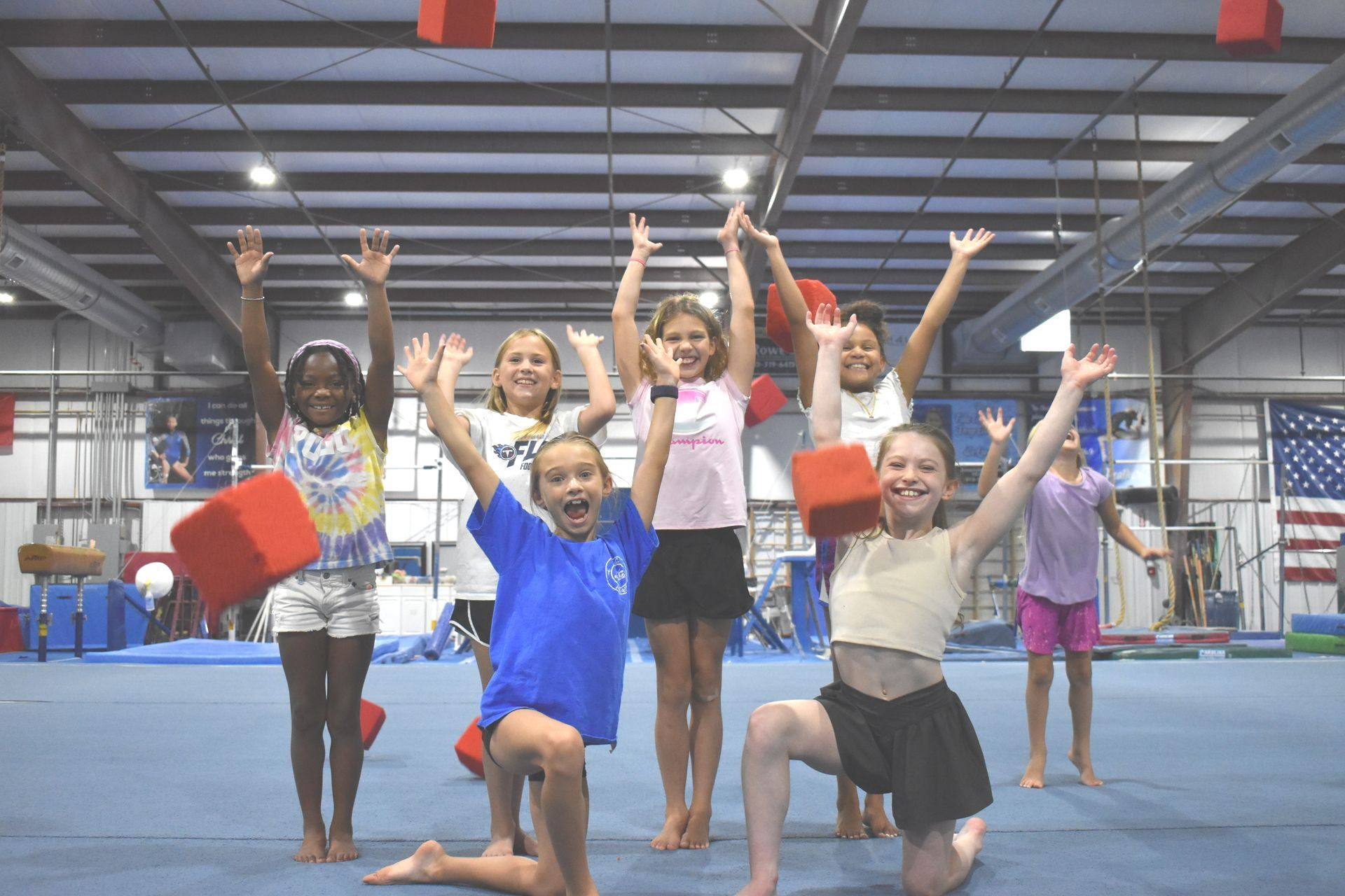 A group of young girls are posing for a picture in a gym.