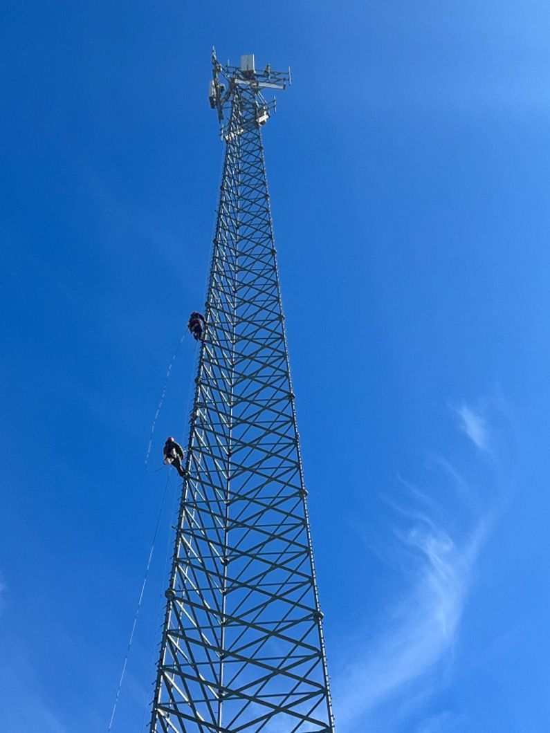 A very tall metal tower with a blue sky in the background.