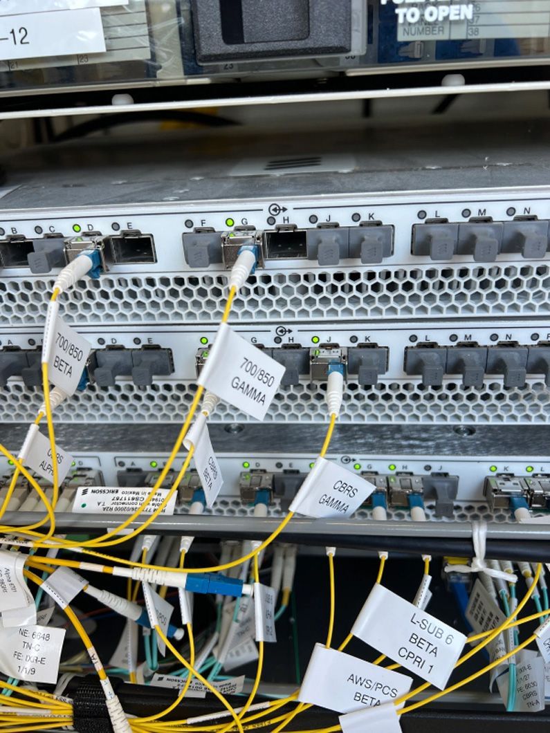 A bunch of wires are connected to a stack of servers