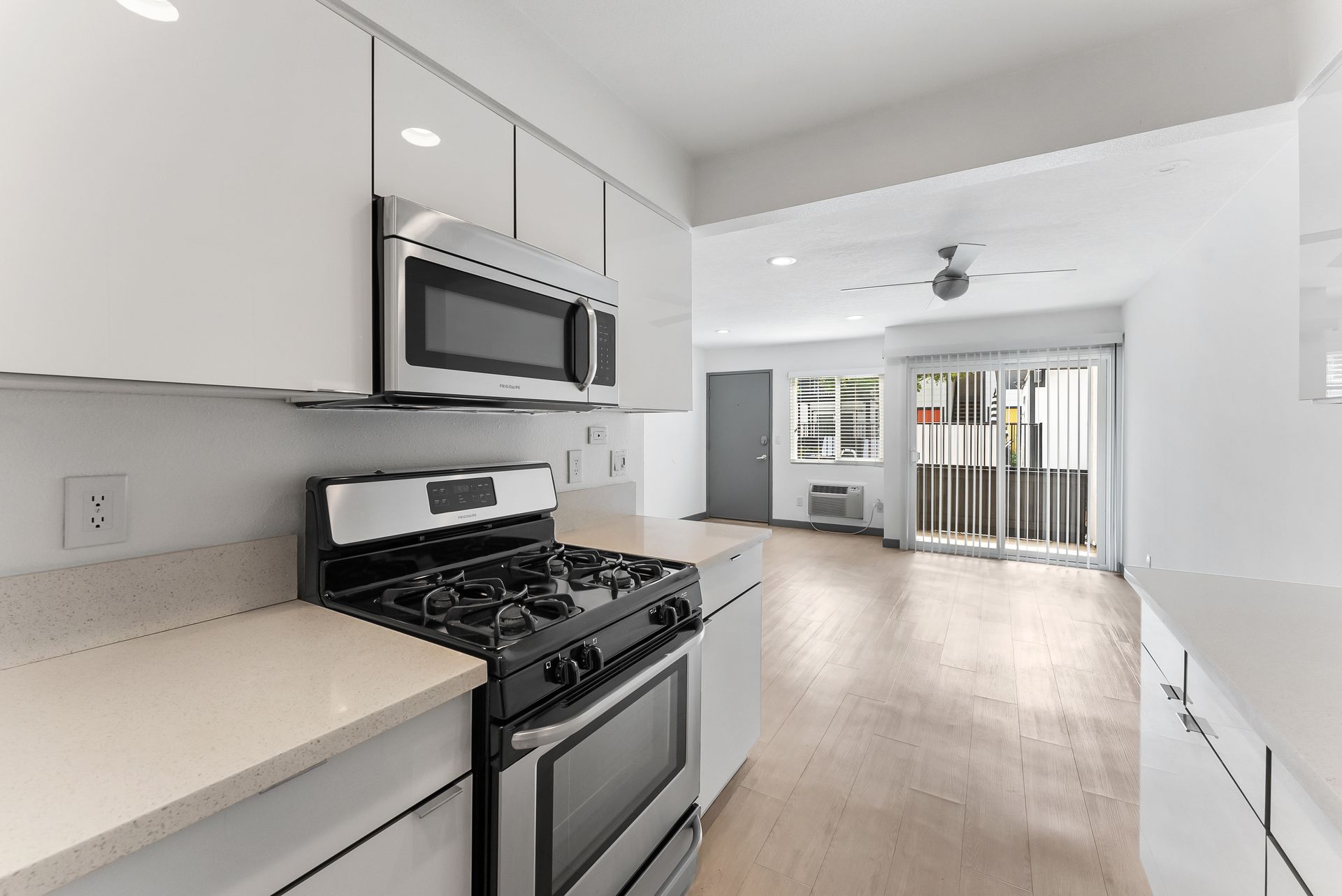 Sliding Photo Gallery Displaying Apartment Features- Kitchen with black stove and sliding door to patio