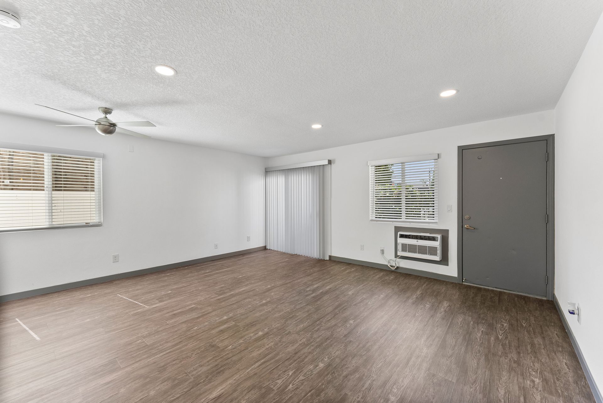 Sliding Photo Gallery Displaying Apartment Features- Open living room with wood floors and large window