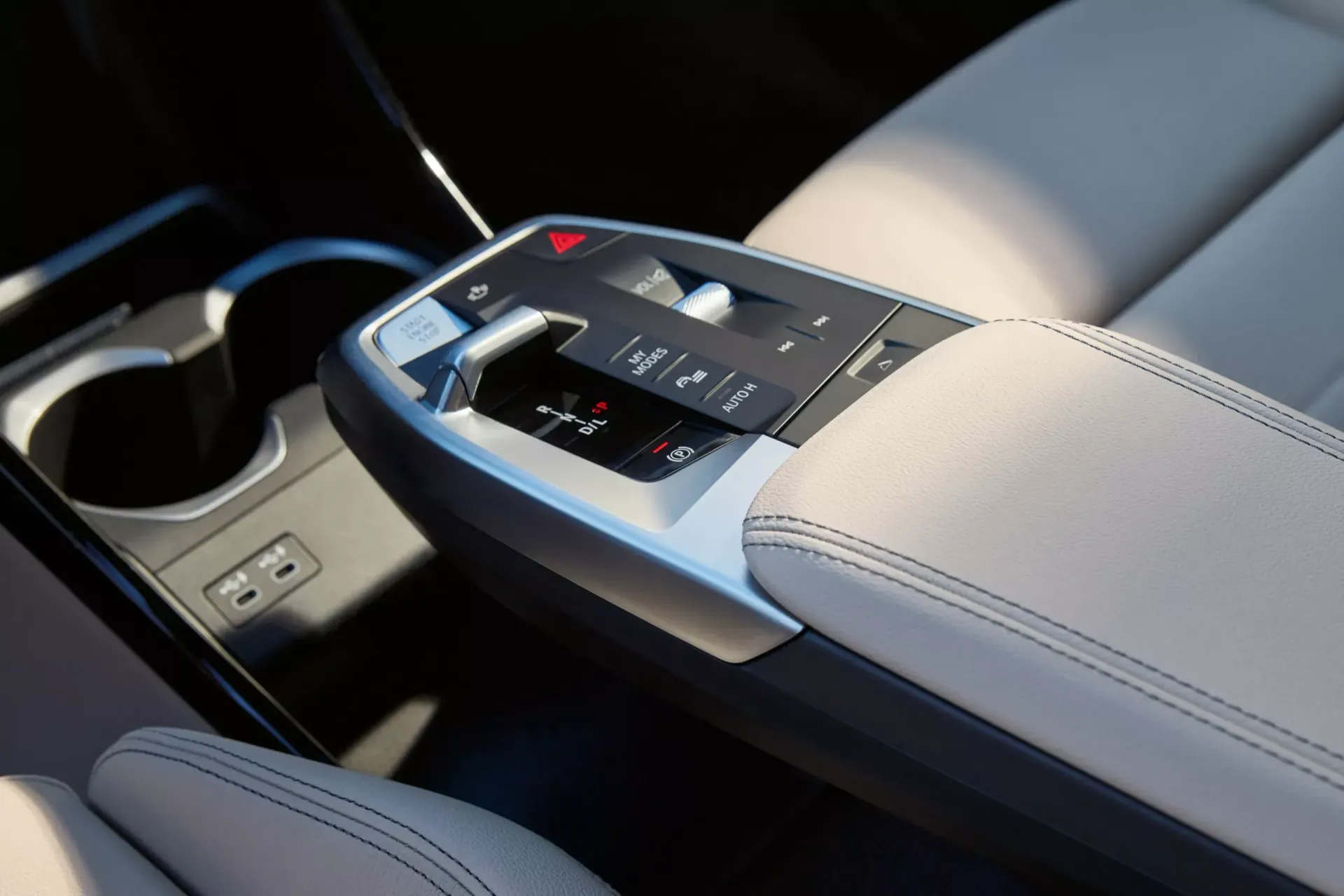 Car interior detail showing center console with gear selector and cup holder.