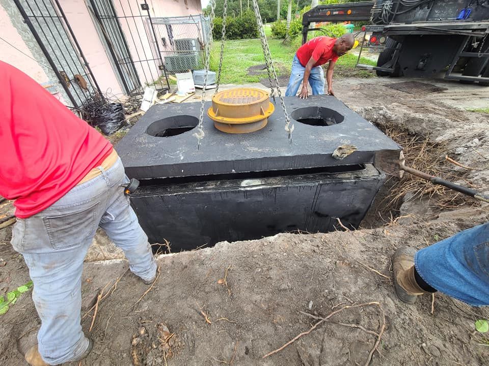 Men installing a septic tank cover in a yard.