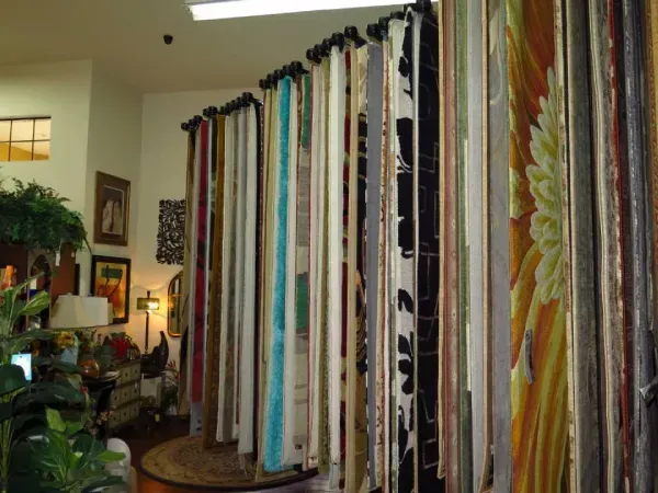 Rows of fabric samples in a retail store, various colors and patterns.