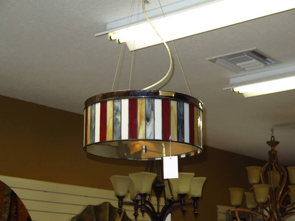 Multi-colored striped drum shade pendant light hanging from the ceiling.