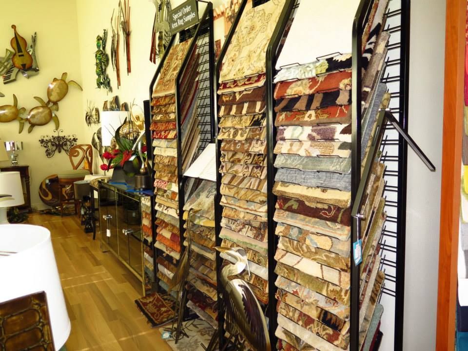 Display rack with carpet samples in a shop, plus metal art and a lamp.