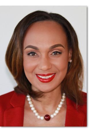 A woman wearing a red jacket and a pearl necklace